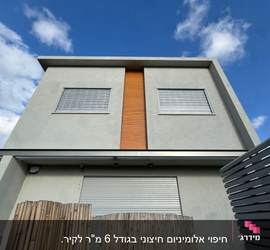בניין עם חלונות ותריסים, שמיים כחולים